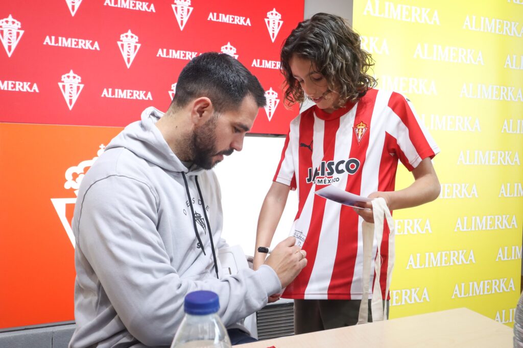 Pablo Insua firmando una camiseta a una niña