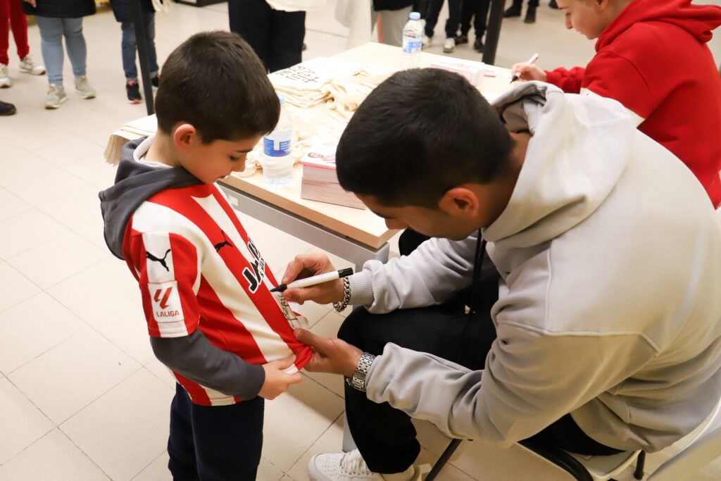 Cote firmando una camiseta a un niño