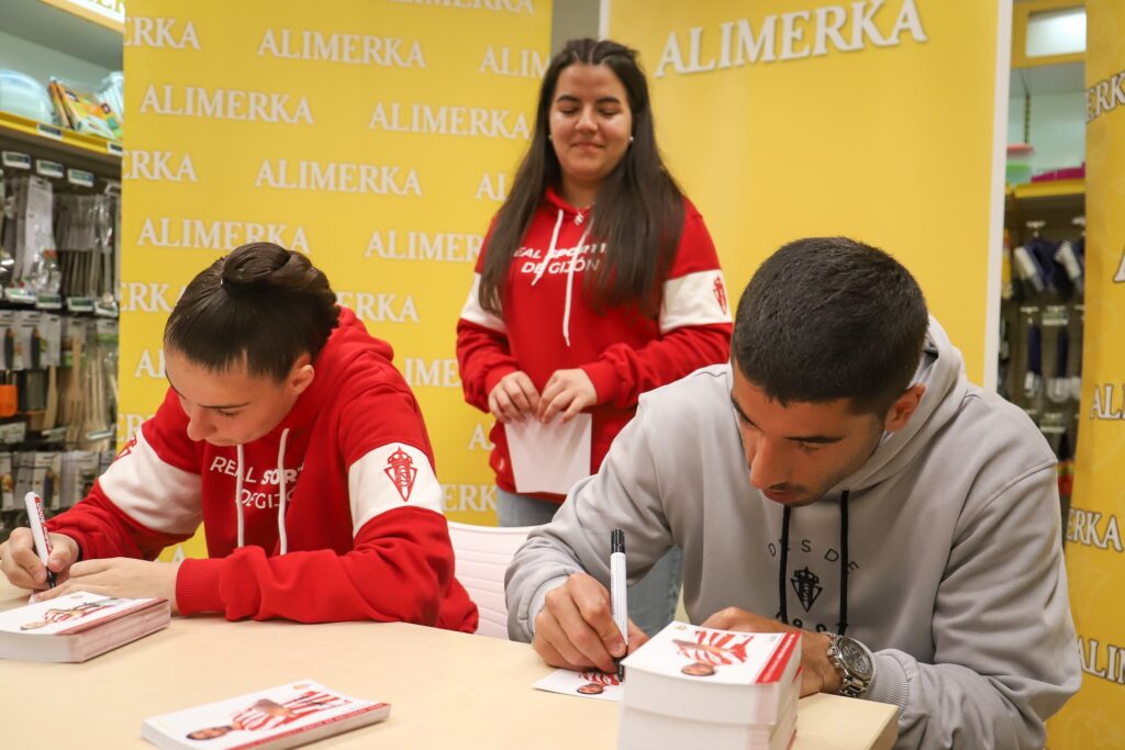 Cote y Mariuca firmando autógrafos con un niña detrás