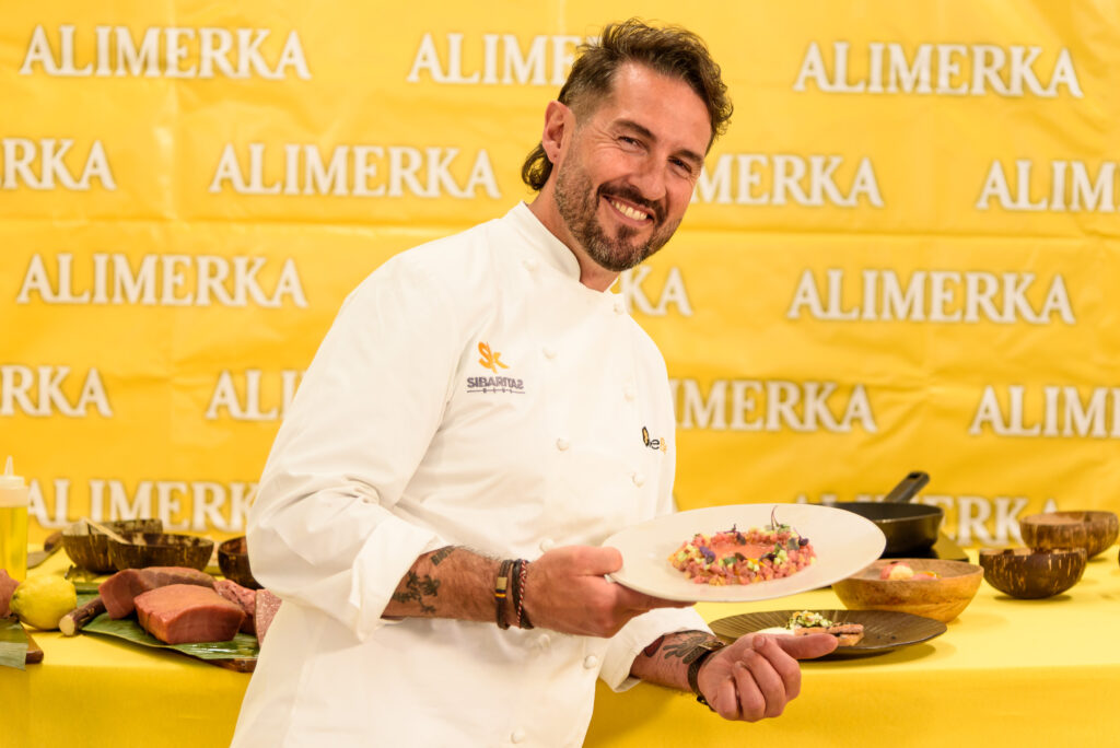 Javier Peña sujetando uno de los platos con el fondo Alimerka